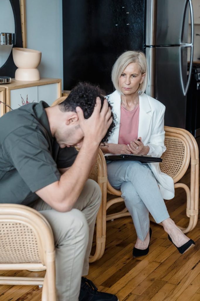 A therapist counseling a stressed client during a session indoors.